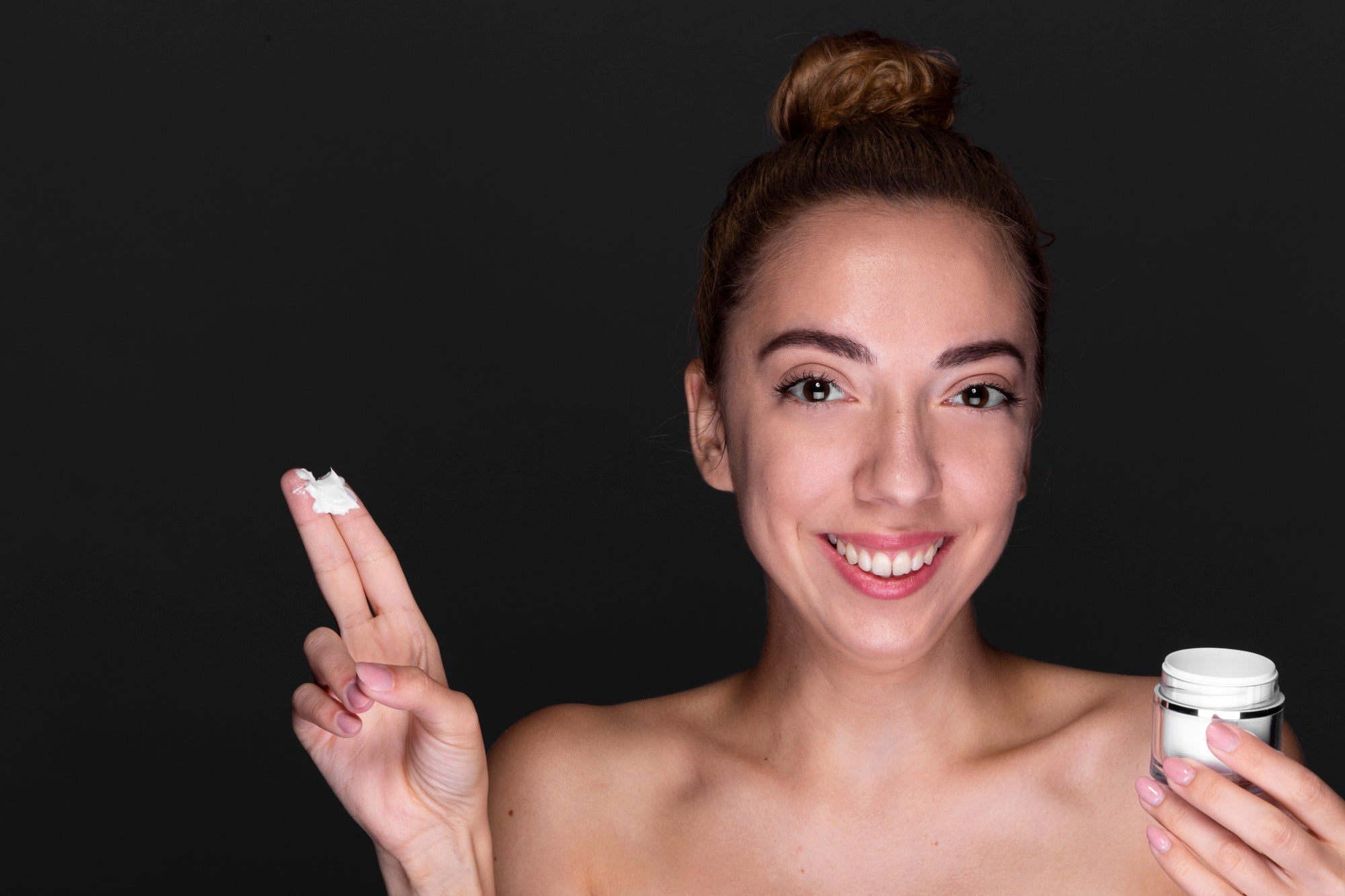 Femme montrant une crème visage